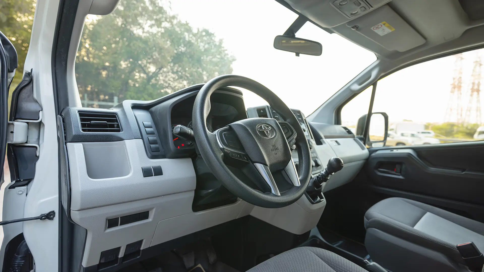 Used 2022 Toyota Hiace GL High Roof in White – Driver Side Dashboard & Steering View for Sale at First Choice Cars Dubai Sharjah
