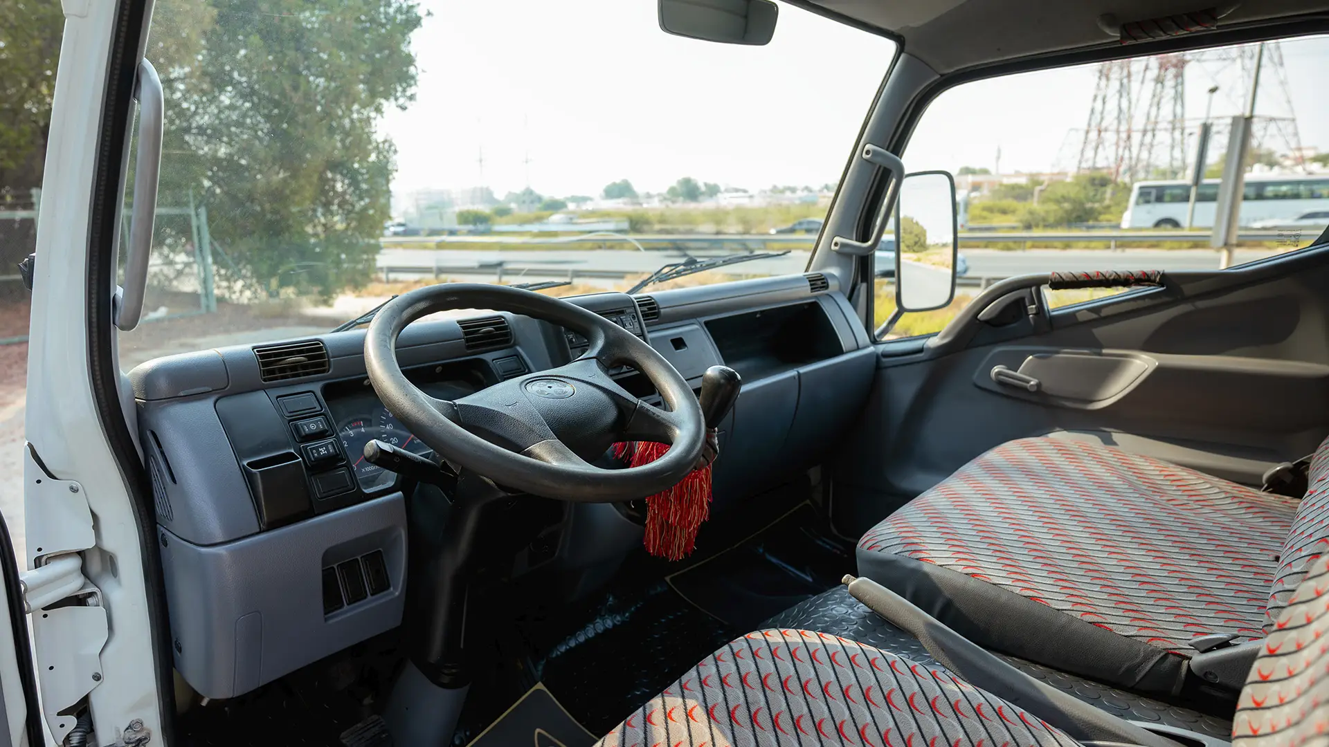 Used 2016 Mitsubishi Canter Double Cabin Cargo Body in White – Driver Side Dashboard & Steering View for Sale at First Choice Cars Dubai Sharjah
