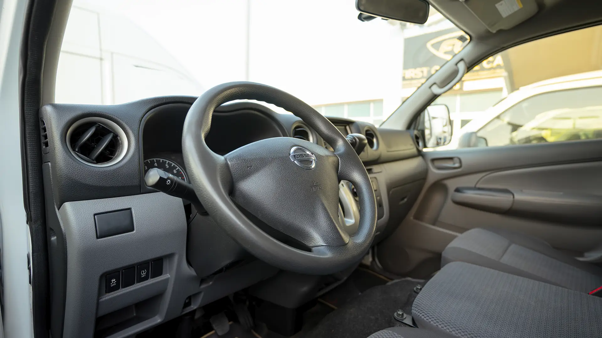 Used 2022 Nissan Urvan Standard Roof in White – Driver Side Dashboard & Steering View for Sale at First Choice Cars Dubai Sharjah