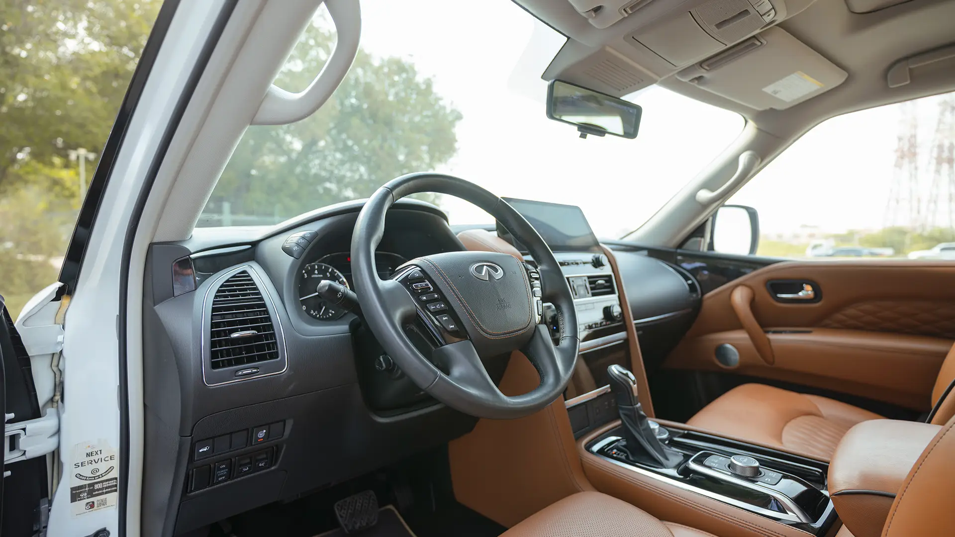 Used 2024 Infiniti QX80 Sensory in White – Driver Side Dashboard & Steering View for Sale at First Choice Cars Dubai Sharjah