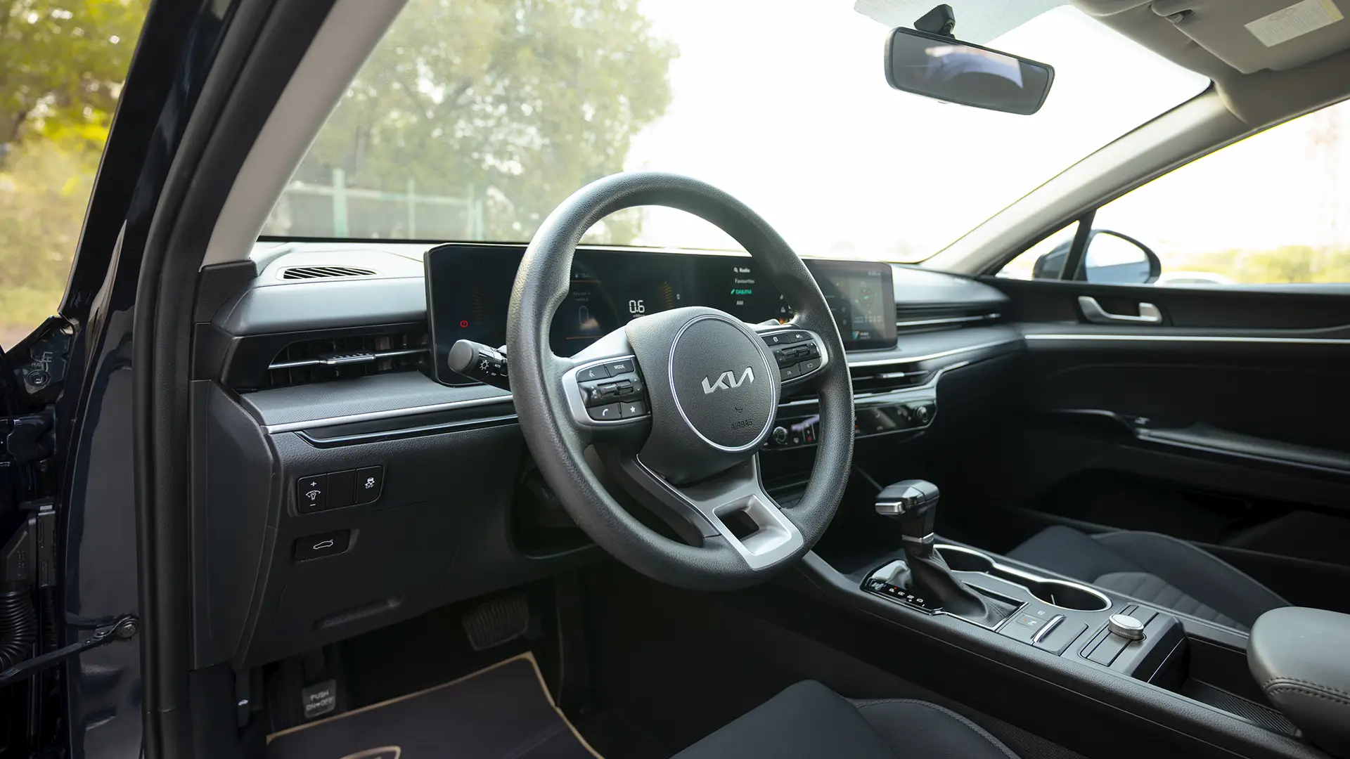 Used 2024 Kia K5 LX in White – Driver Side Dashboard & Steering View for Sale at First Choice Cars Dubai Sharjah