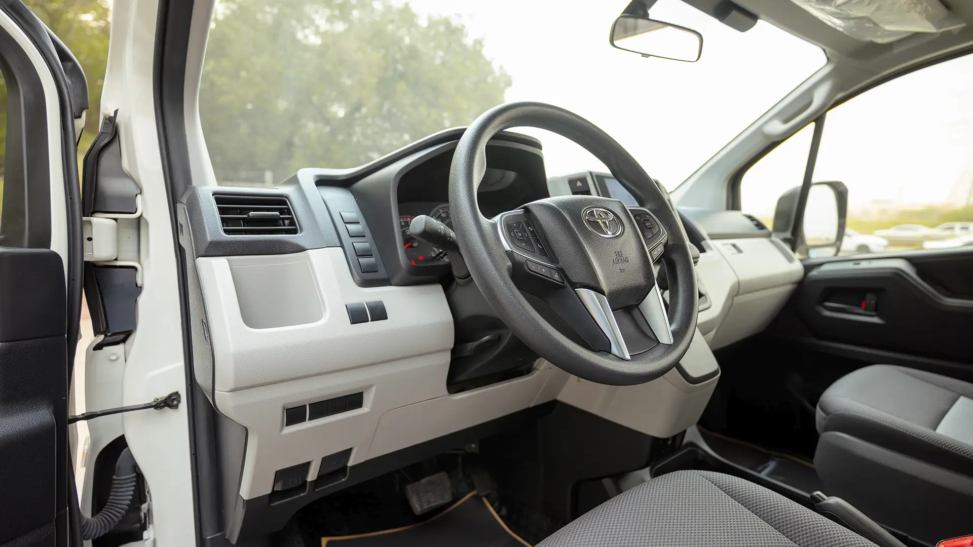 Used 2026 Toyota Hiace GL High Roof in White – Driver Side Dashboard & Steering View for Sale at First Choice Cars Dubai Sharjah