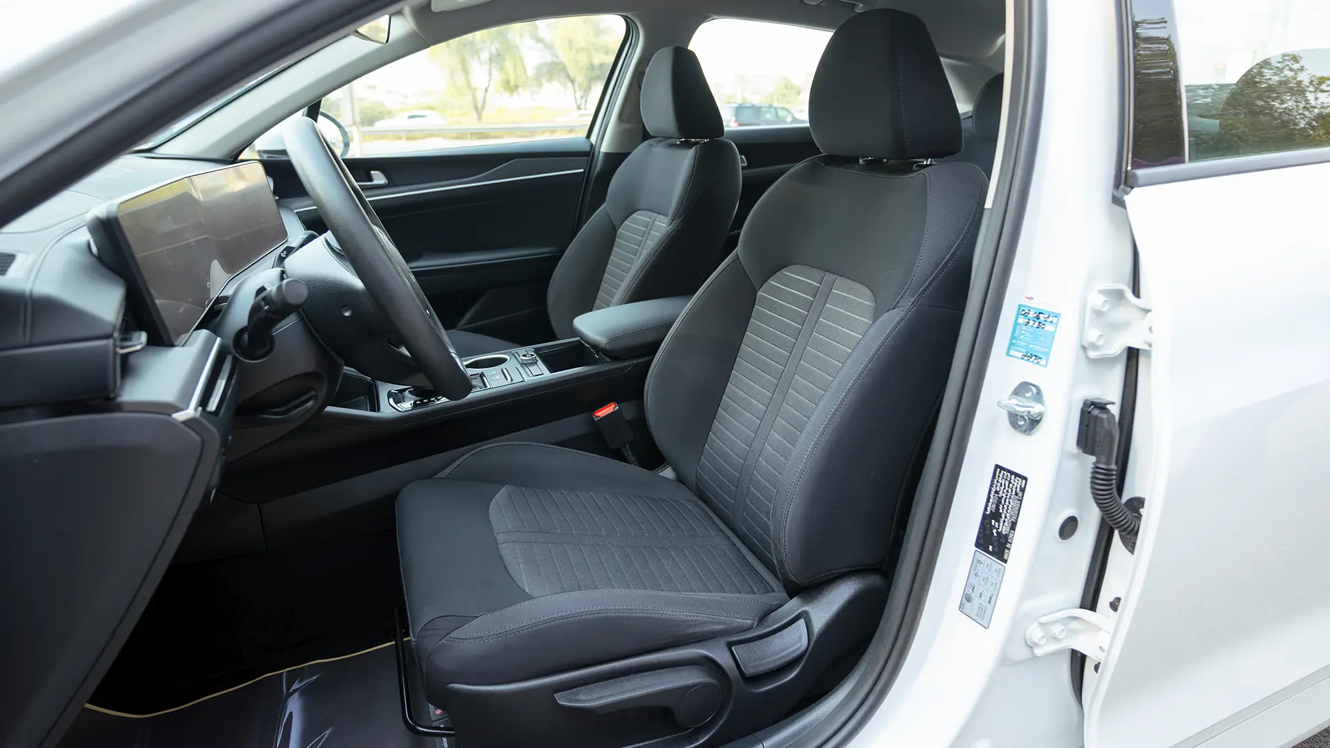 Used 2024 Kia K5 LX in White – Front Driver Side Cabin View for Sale at First Choice Cars Dubai Sharjah