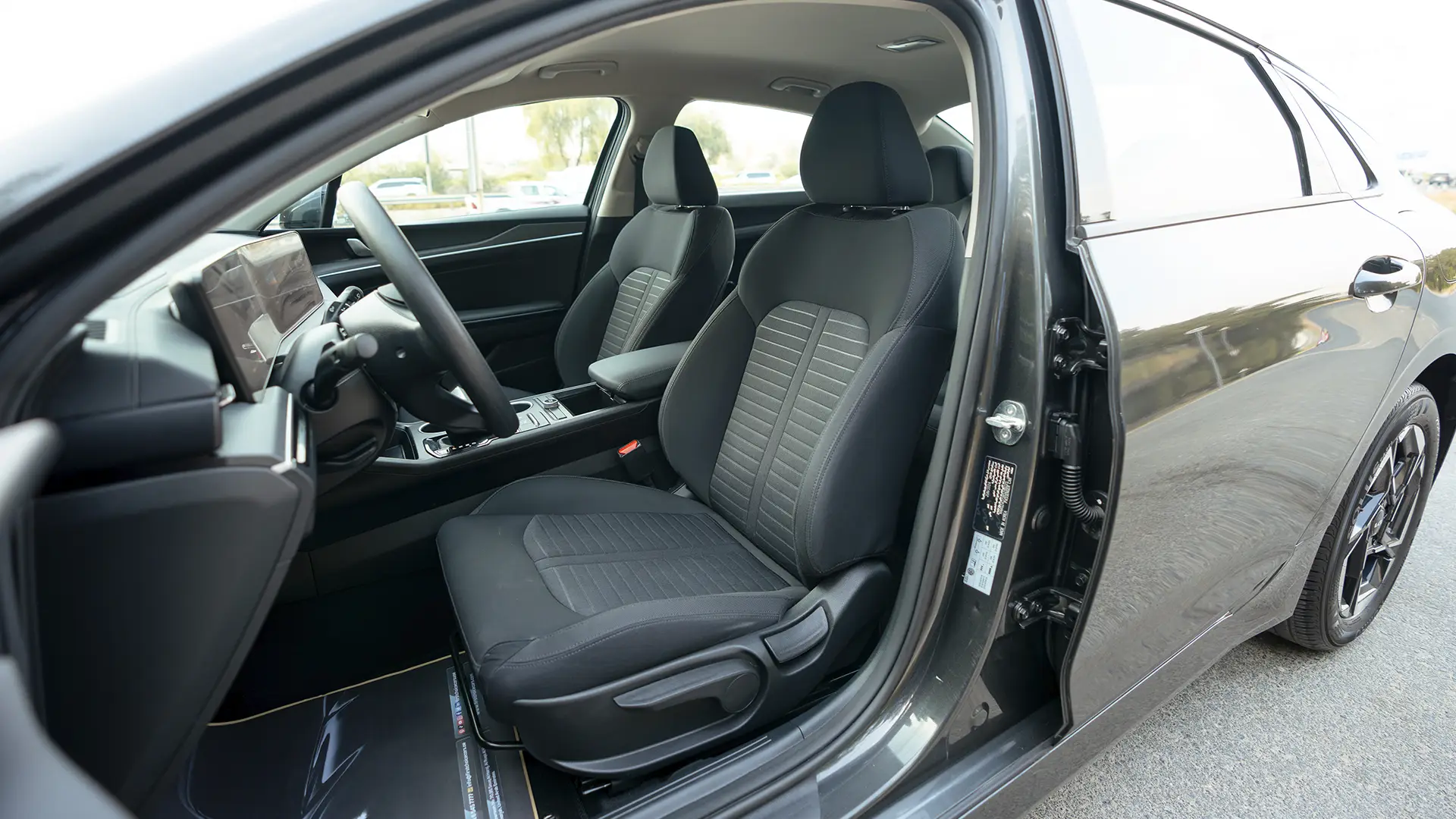 Used 2024 Kia K5 LX in Grey – Front Driver Side Cabin View for Sale at First Choice Cars Dubai Sharjah