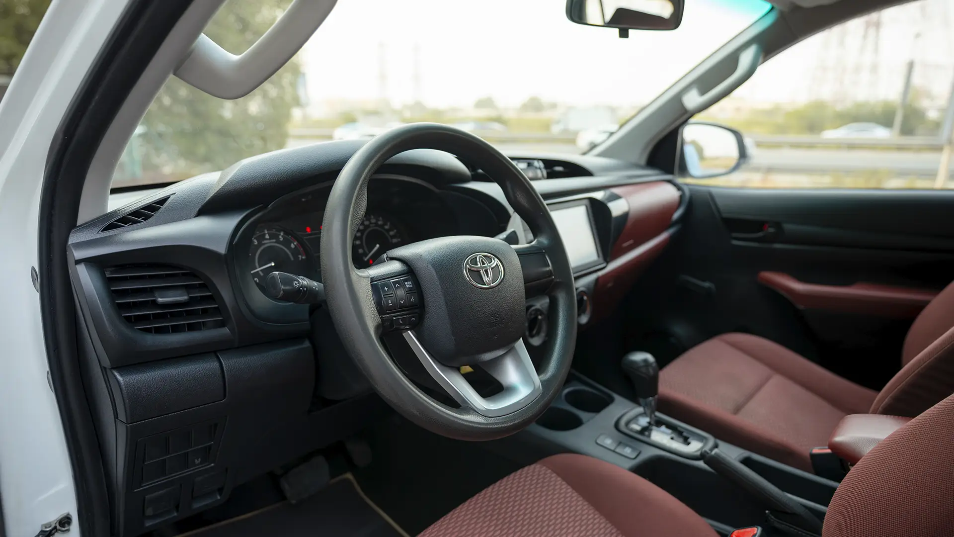 Used 2021 Toyota Hilux GLX Double Cabin in White – Driver Side Dashboard & Steering View for Sale at First Choice Cars Dubai Sharjah