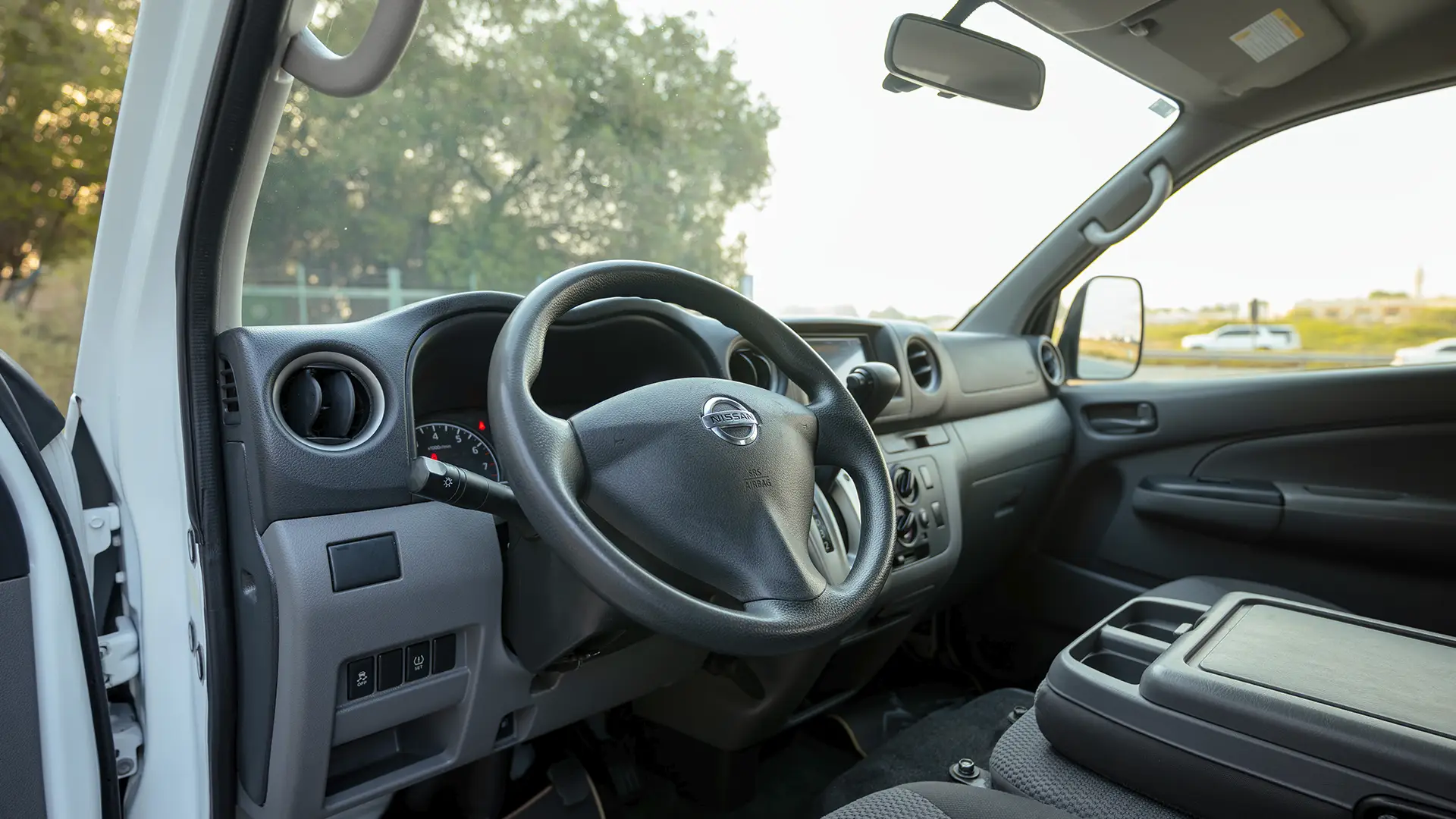 Used 2022 Nissan Urvan Standard Roof in White – Driver Side Dashboard & Steering View for Sale at First Choice Cars Dubai Sharjah