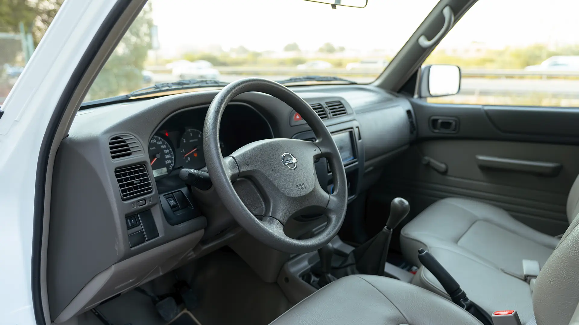 Used 2022 Nissan Patrol Pickup GL in White – Driver Side Dashboard & Steering View for Sale at First Choice Cars Dubai Sharjah