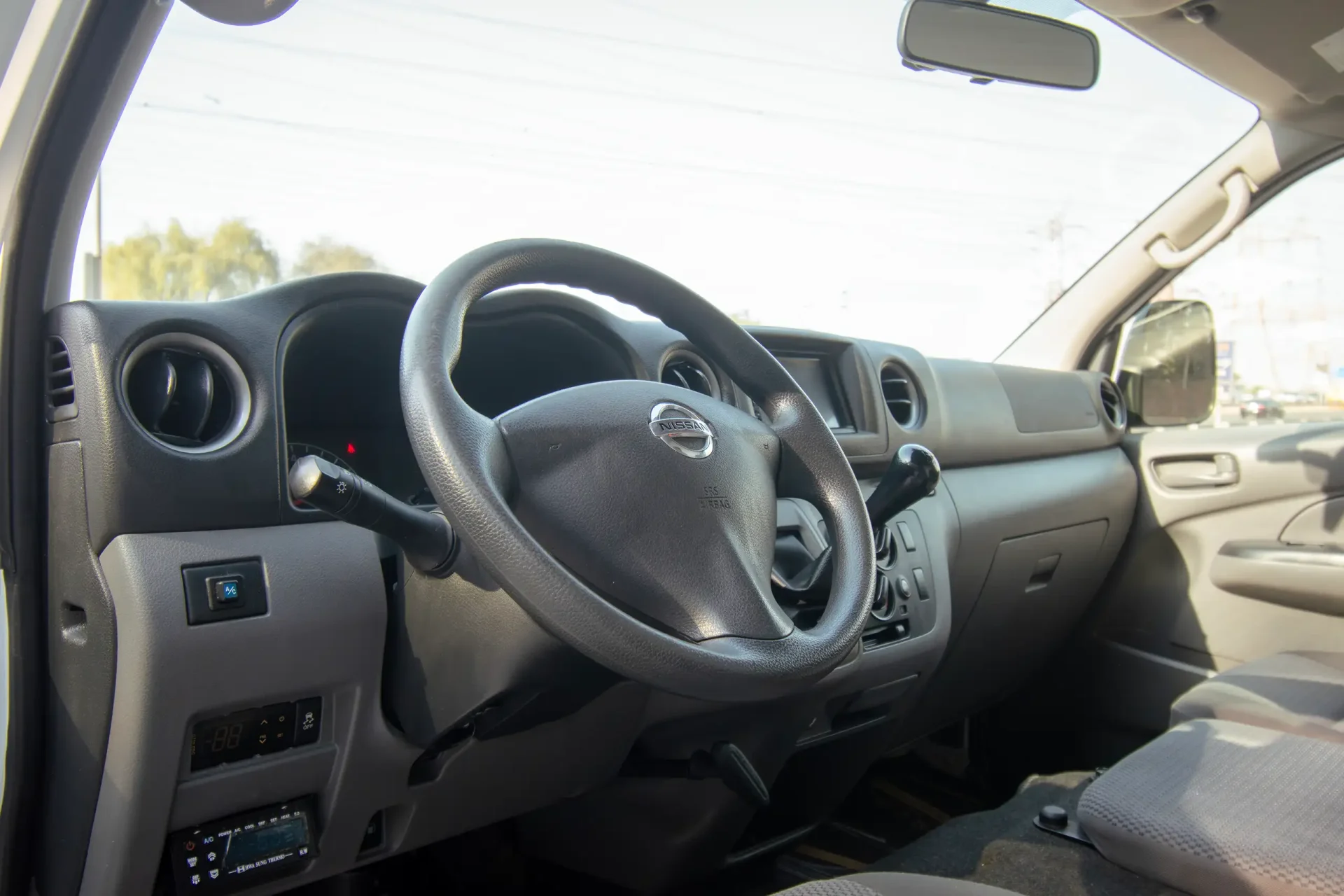 Used 2022 Nissan Urvan High Roof in White – Driver Side Dashboard & Steering View for Sale at First Choice Cars Dubai Sharjah