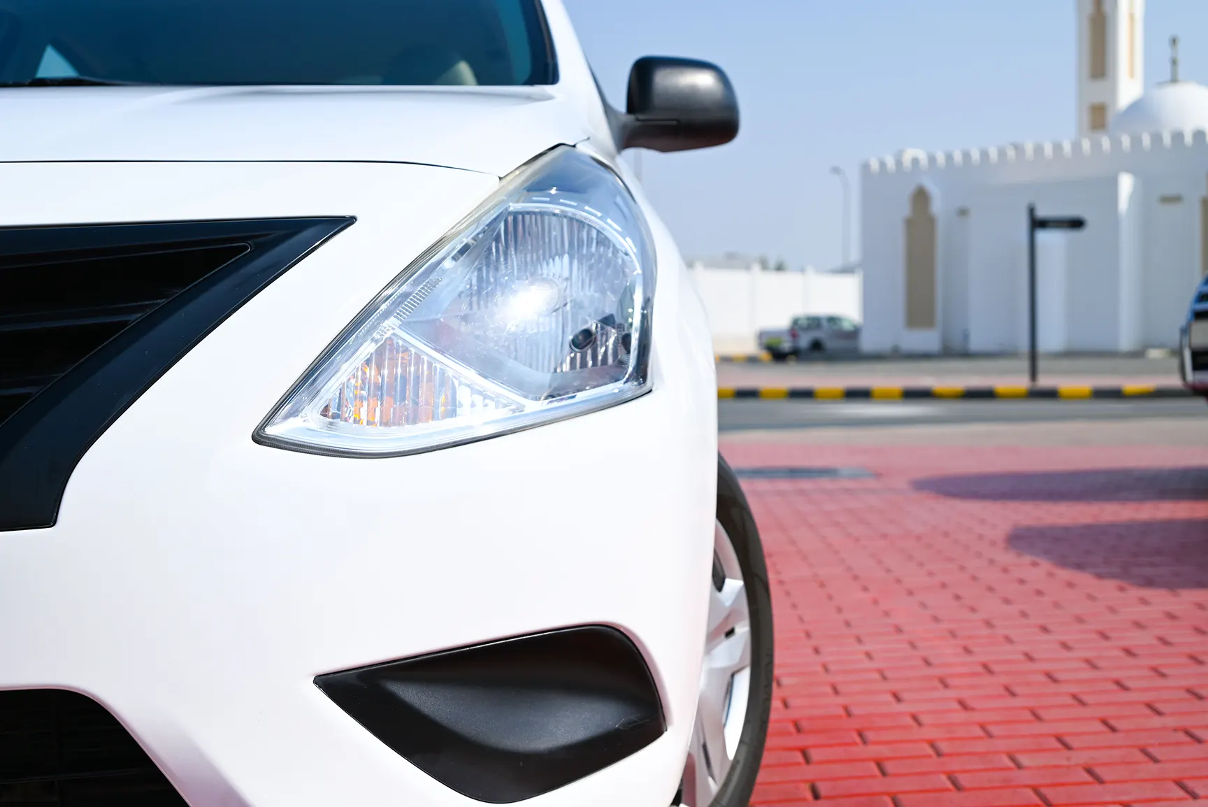 Used 2018 Nissan Sunny S White – Headlight Close-up at First Choice Cars Sharjah