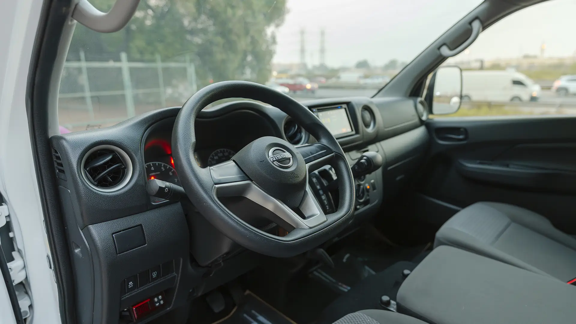Used 2023 Nissan Urvan Standard Roof in White – Driver Side Dashboard & Steering View for Sale at First Choice Cars Dubai Sharjah