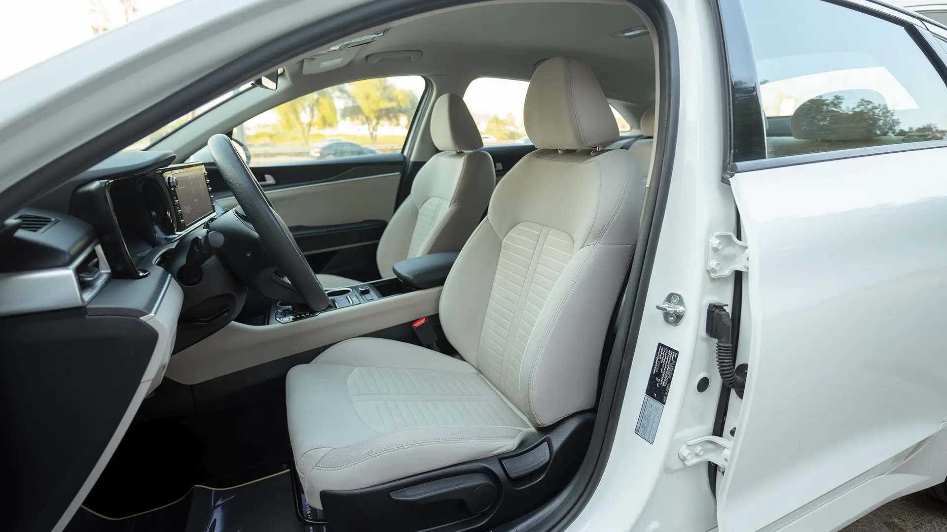 Used 2023 Kia K5 EX in White – Front Driver Side Cabin View for Sale at First Choice Cars Dubai Sharjah