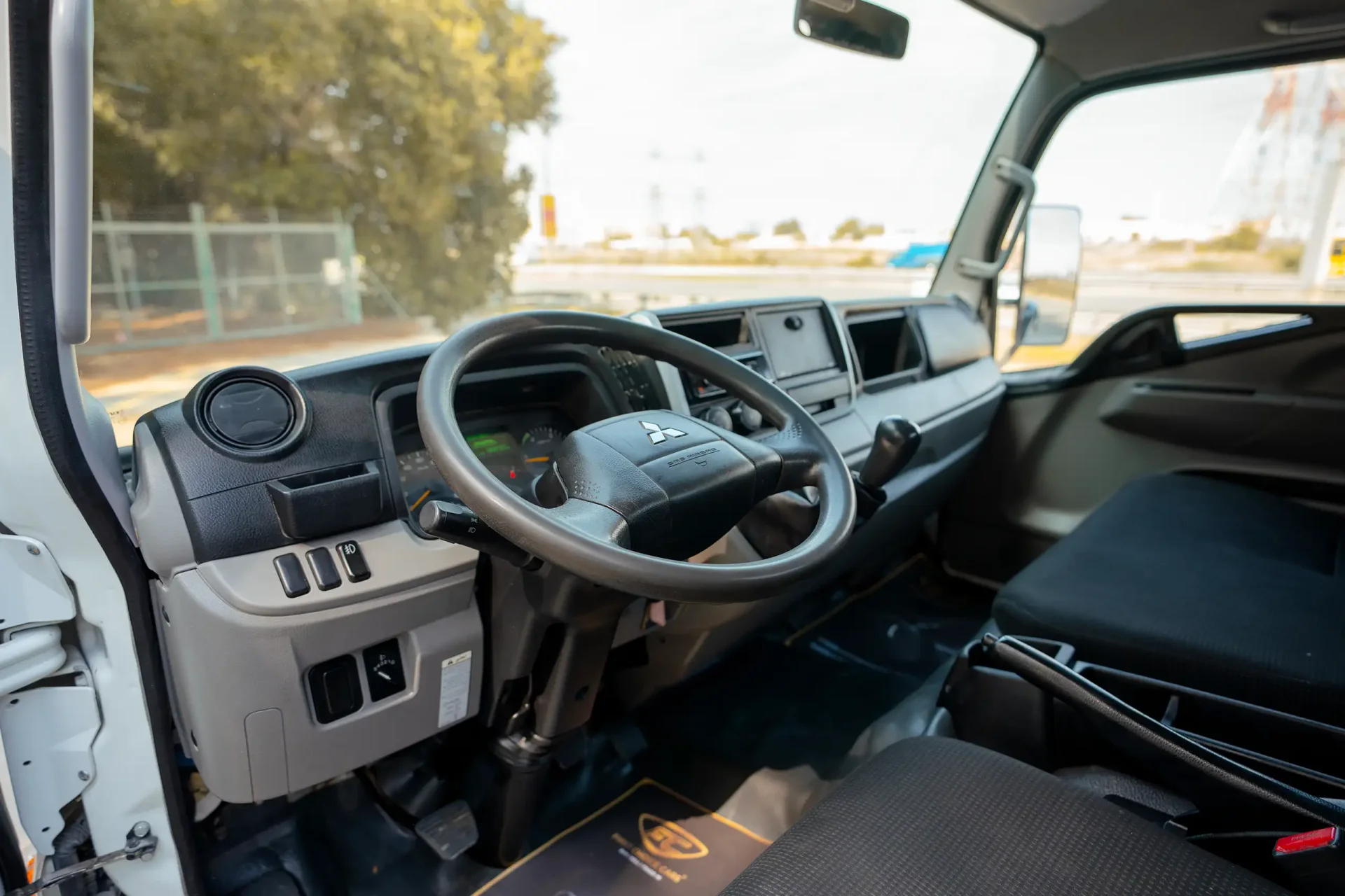 Used 2023 Mitsubishi Canter Cargo Body in White – Driver Side Dashboard & Steering View for Sale at First Choice Cars Dubai Sharjah